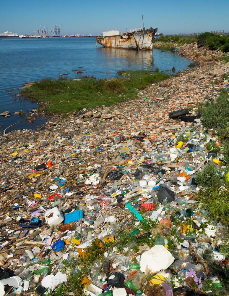 A coastal area heavily polluted with various types of plastic and other debris, plastic waste is lessened by CDF's eco-conscious packaging for adhesives