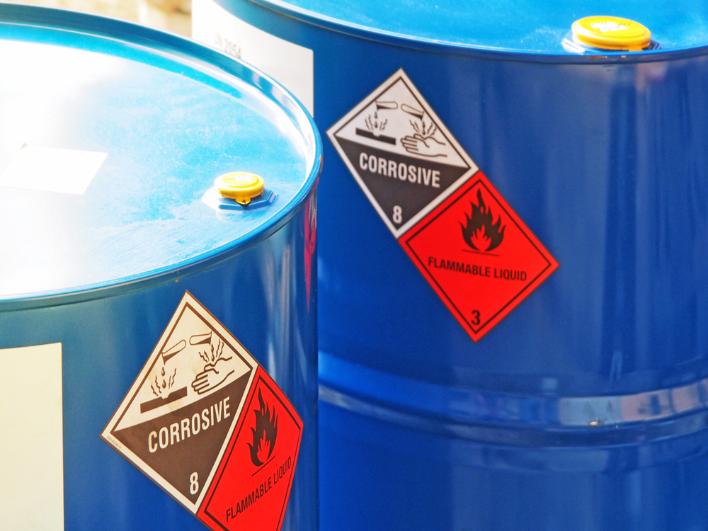 two blue barrels with "corrosive" and "flammable liquid" warning labels -- added protection provided by the anti-static bags inside